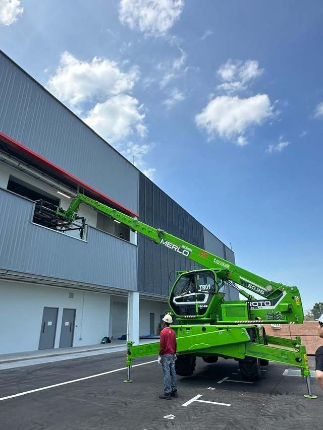 Merlo Roto rotating telehandler placing materials onto an upper floor of a construction site in Johor